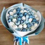Biało-błękitny bukiet tulipanów z pianki marshmallow na drewnianym blacie