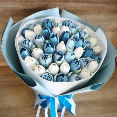 Biało-błękitny bukiet tulipanów z pianki marshmallow na drewnianym blacie