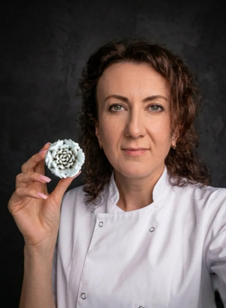 Nadia, założycielka pracowni Grafinka, trzyma w dłoni ręcznie uformowany kwiat z pianki marshmallow